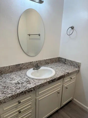 a bathroom with a granite countertop sink and a mirror