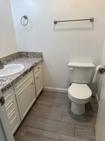 a bathroom with a granite countertop toilet and a sink