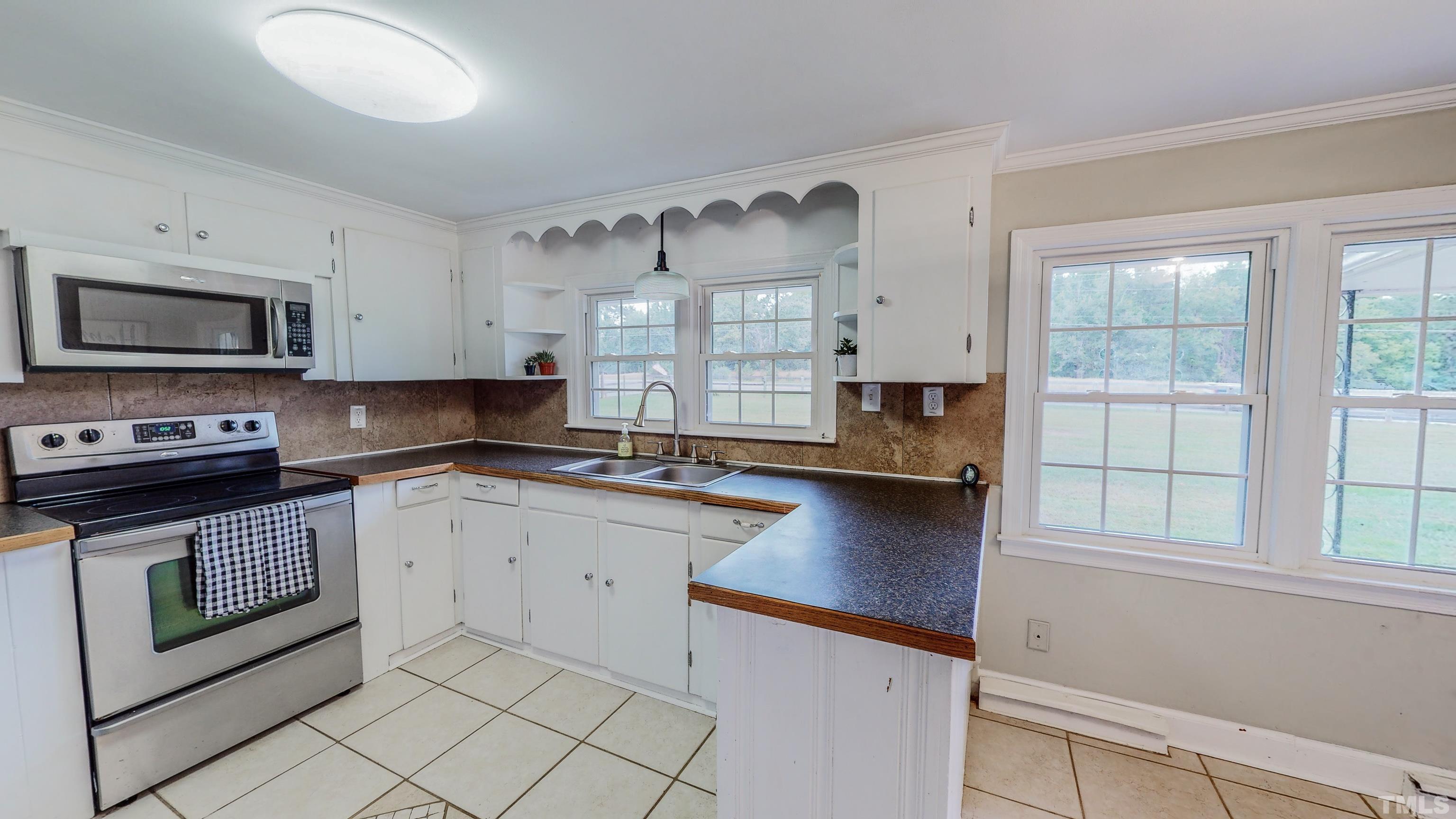 3920 Oxford Road Roxboro, NC 27574 - Photo 5 of 30 a kitchen with granite countertop a stove a sink and a microwave