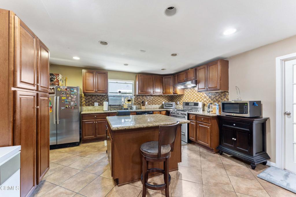 1421 East Abbottson Street Carson, CA 90746 - Photo 6 of 18 a kitchen with stainless steel appliances granite countertop a refrigerator a sink a stove a microwave and a refrigerator