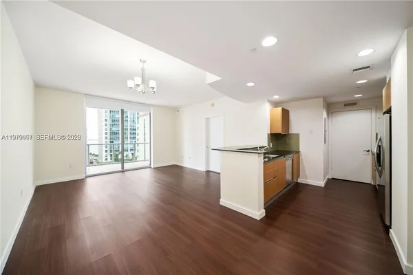 a view of kitchen with refrigerator and wooden floor