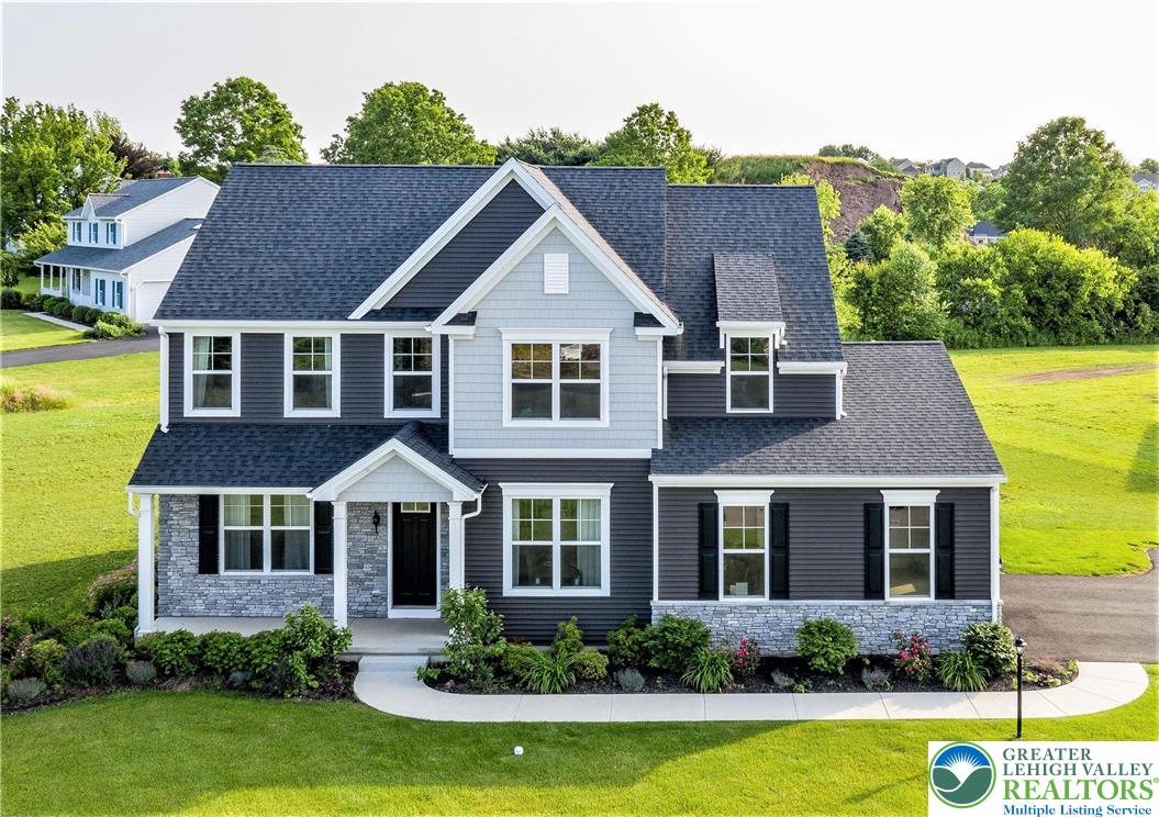 a front view of a house with a yard and potted plants