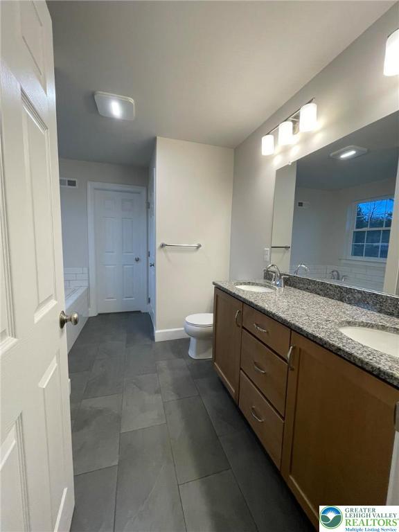 5043 Chapmans Road Orefield, PA 18069 - Photo 16 of 18 a bathroom with a granite countertop sink a toilet and a mirror