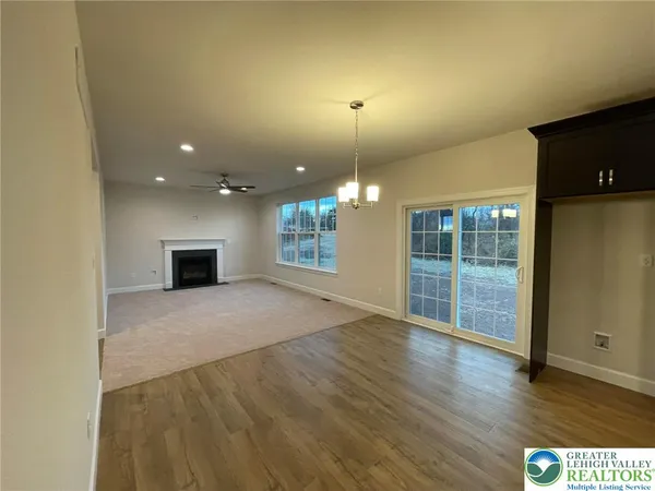 an empty room with windows and fireplace