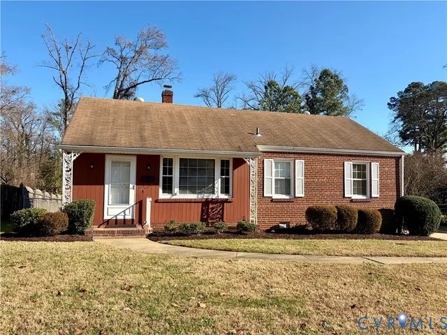a front view of house with yard and trees in the background