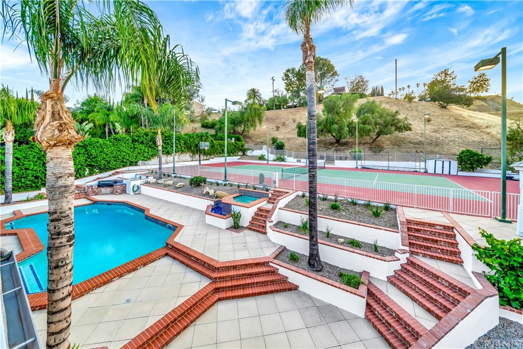 22963 Cass Avenue Woodland Hills, CA 91364 - Photo 52 of 66 a view of a patio with table and chairs potted plants with palm trees