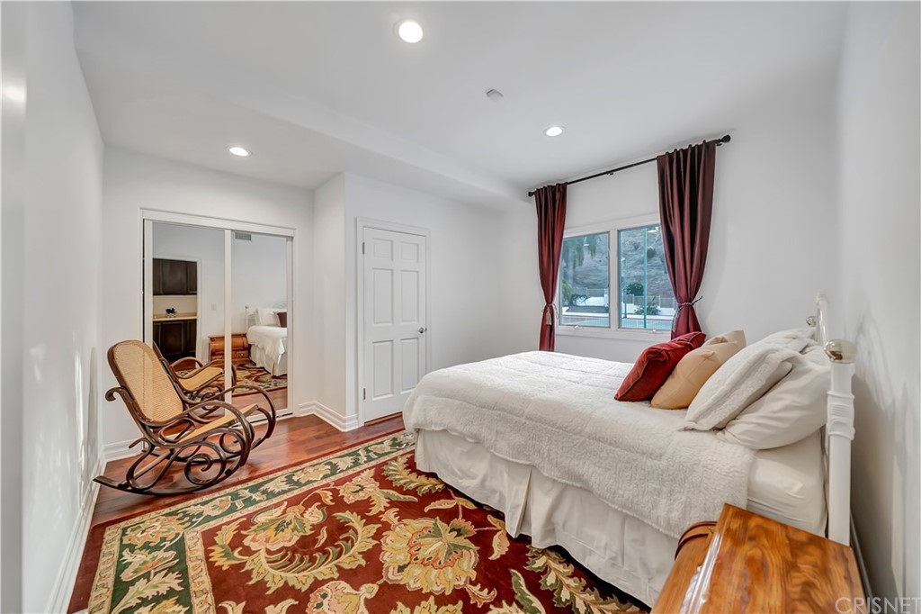 22963 Cass Avenue Woodland Hills, CA 91364 - Photo 55 of 66 a bedroom with a bed and wooden floor