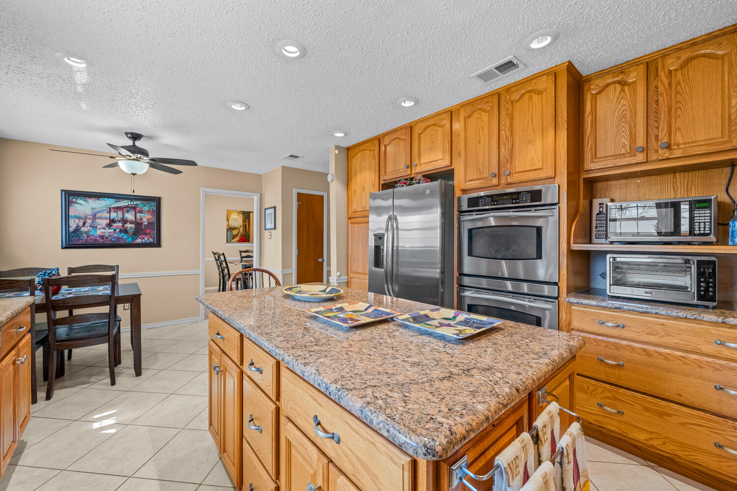 1500 West Lynn Street Slaton, TX 79364 - Photo 13 of 37 a kitchen with kitchen island granite countertop wooden cabinets and a counter top space