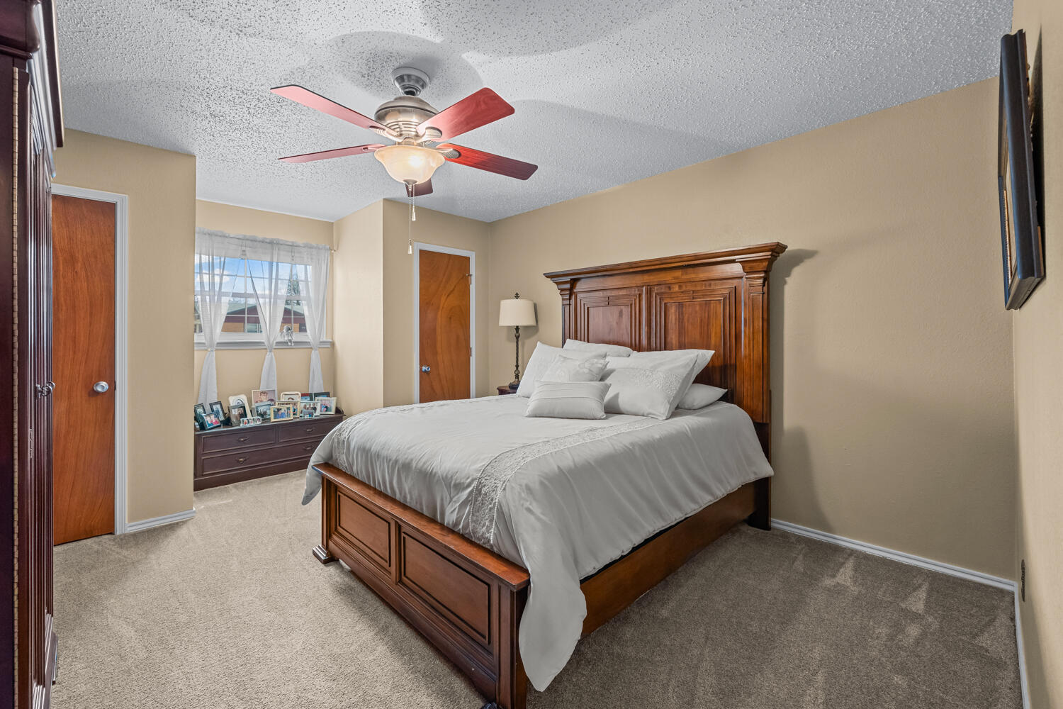 1500 West Lynn Street Slaton, TX 79364 - Photo 19 of 37 a spacious bedroom with a bed and a chandelier