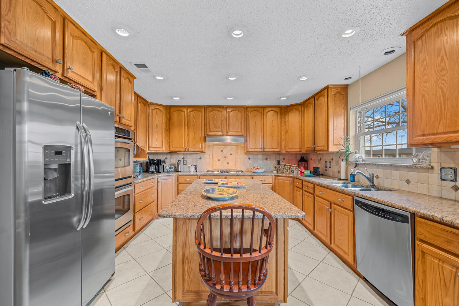 1500 West Lynn Street Slaton, TX 79364 - Photo 9 of 37 a kitchen with stainless steel appliances granite countertop a refrigerator a sink a stove and island