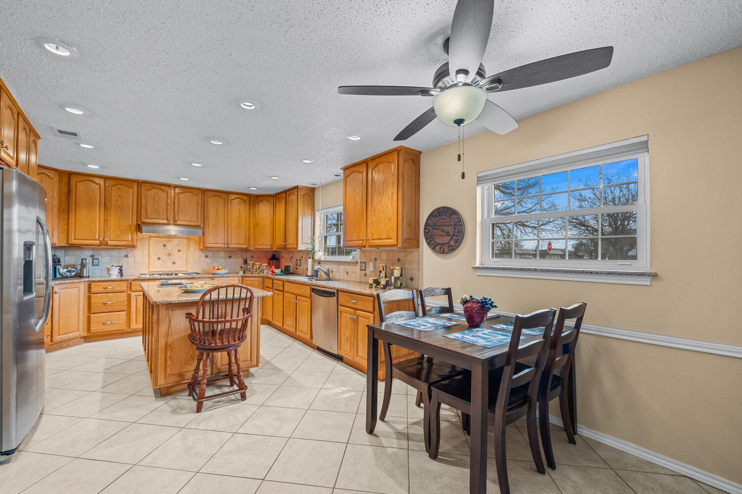 1500 West Lynn Street Slaton, TX 79364 - Photo 10 of 37 a kitchen with stainless steel appliances granite countertop a dining table and chairs