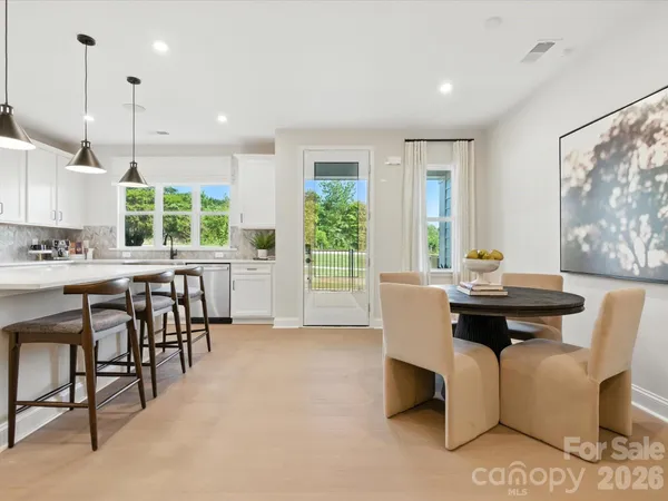 a living room with furniture a large window and dining table