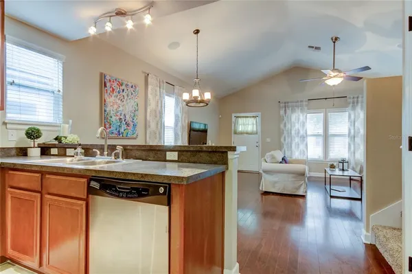a kitchen with kitchen island granite countertop a sink cabinets and wooden floor