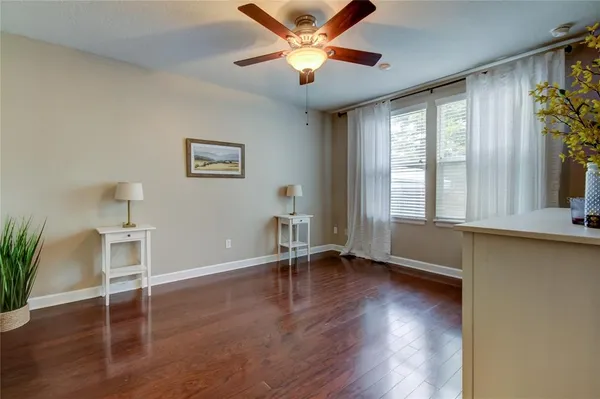 a view of an empty room with a window and wooden floor
