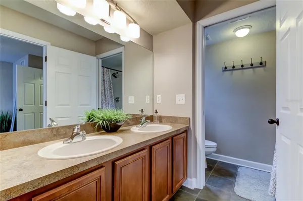 a bathroom with a granite countertop sink a toilet and a mirror