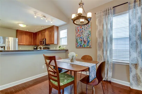 a view of a dining room with furniture a chandelier and wooden floor