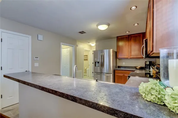 a kitchen with stainless steel appliances granite countertop sink stove refrigerator and cabinets