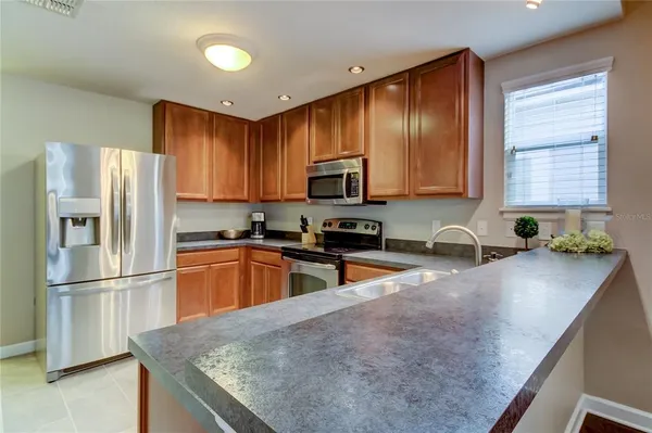 a kitchen with stainless steel appliances granite countertop a refrigerator a stove top oven a sink and dishwasher
