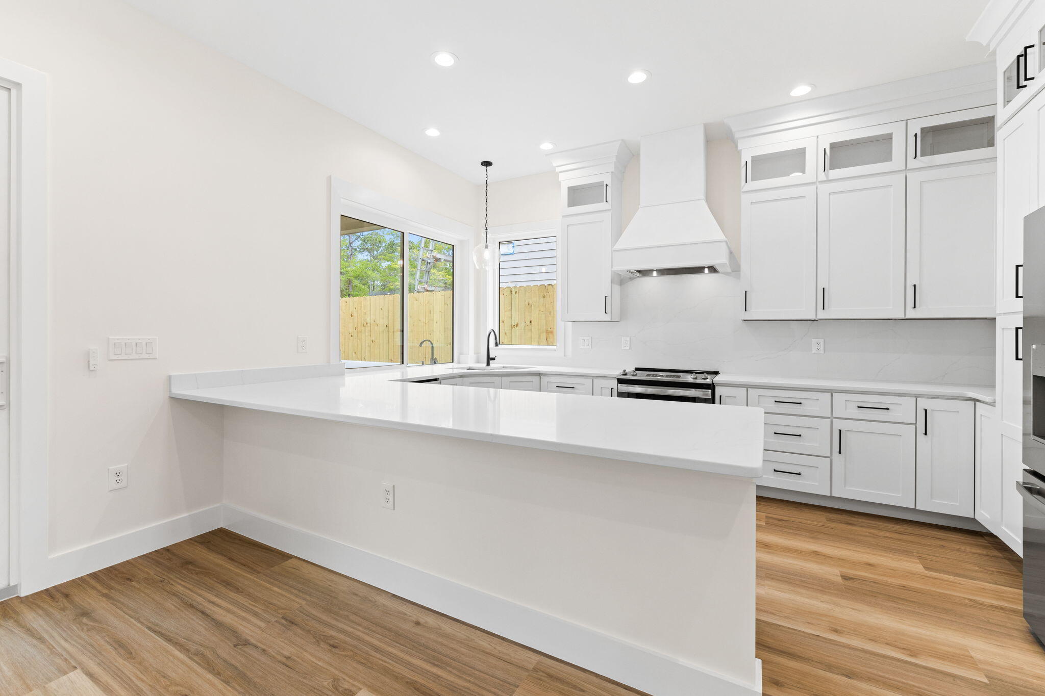 22 Georgie Street Point Washington, FL 32459 - Photo 23 of 57 a kitchen with granite countertop a stove a sink and white cabinets with wooden floor