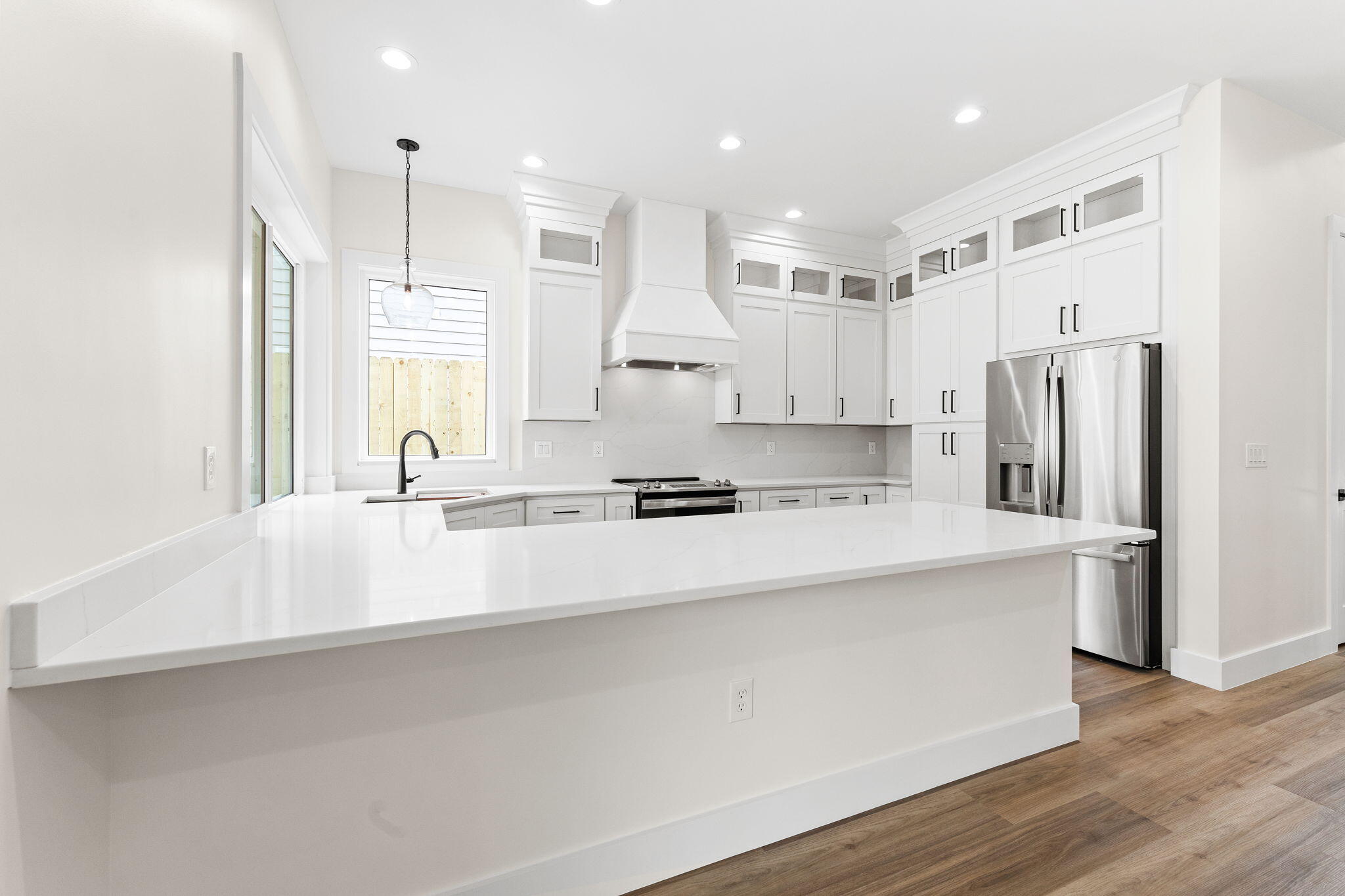 22 Georgie Street Point Washington, FL 32459 - Photo 24 of 57 a large white kitchen with a refrigerator a sink and a stove top oven with wooden floor