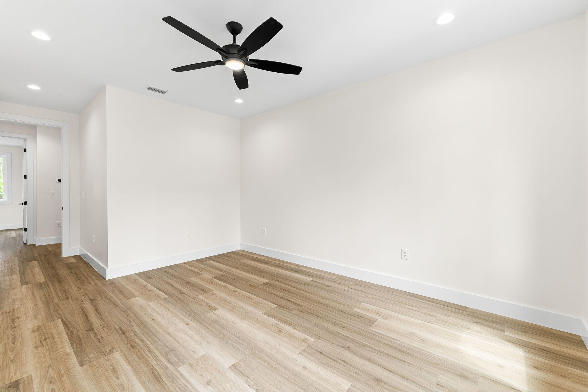 22 Georgie Street Point Washington, FL 32459 - Photo 43 of 57 an empty room with wooden floor and a ceiling fan