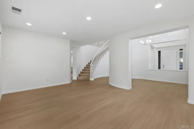 an empty room with wooden floor and stairs