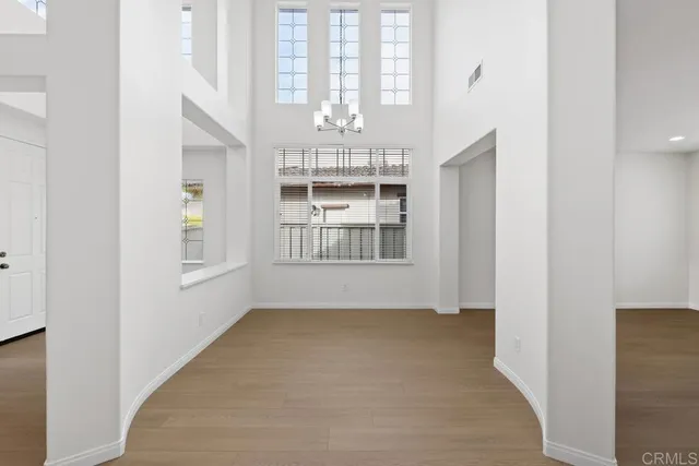 an empty room with chandelier and windows