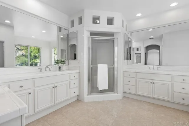 a spacious bathroom with a granite countertop sink mirror and shower