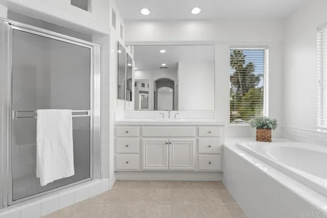 a spacious bathroom with a bathtub sink and mirror
