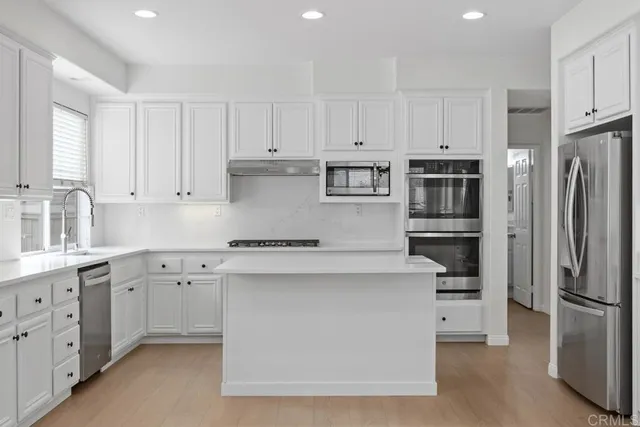 a kitchen with cabinets appliances and a counter space