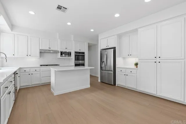 a kitchen with stainless steel appliances a refrigerator sink and cabinets