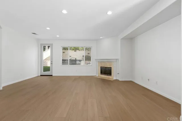 an empty room with windows and fireplace