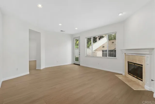an empty room with windows and fireplace