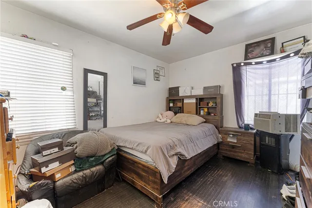 a bedroom with a bed wooden floor and window