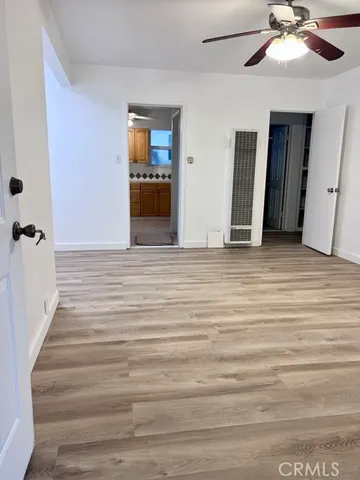 a view of empty room with wooden floor