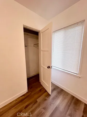 an empty room with wooden floor and closet