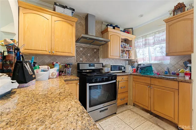 a kitchen with stainless steel appliances granite countertop a stove a sink and a microwave