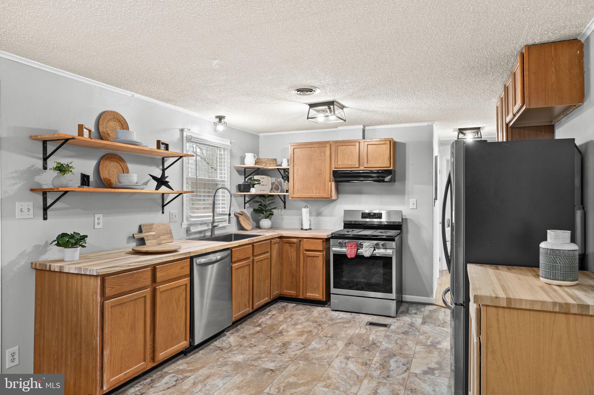9523 Brock Road Spotsylvania, VA 22553 - Photo 17 of 44 a kitchen with stainless steel appliances granite countertop a sink and a refrigerator