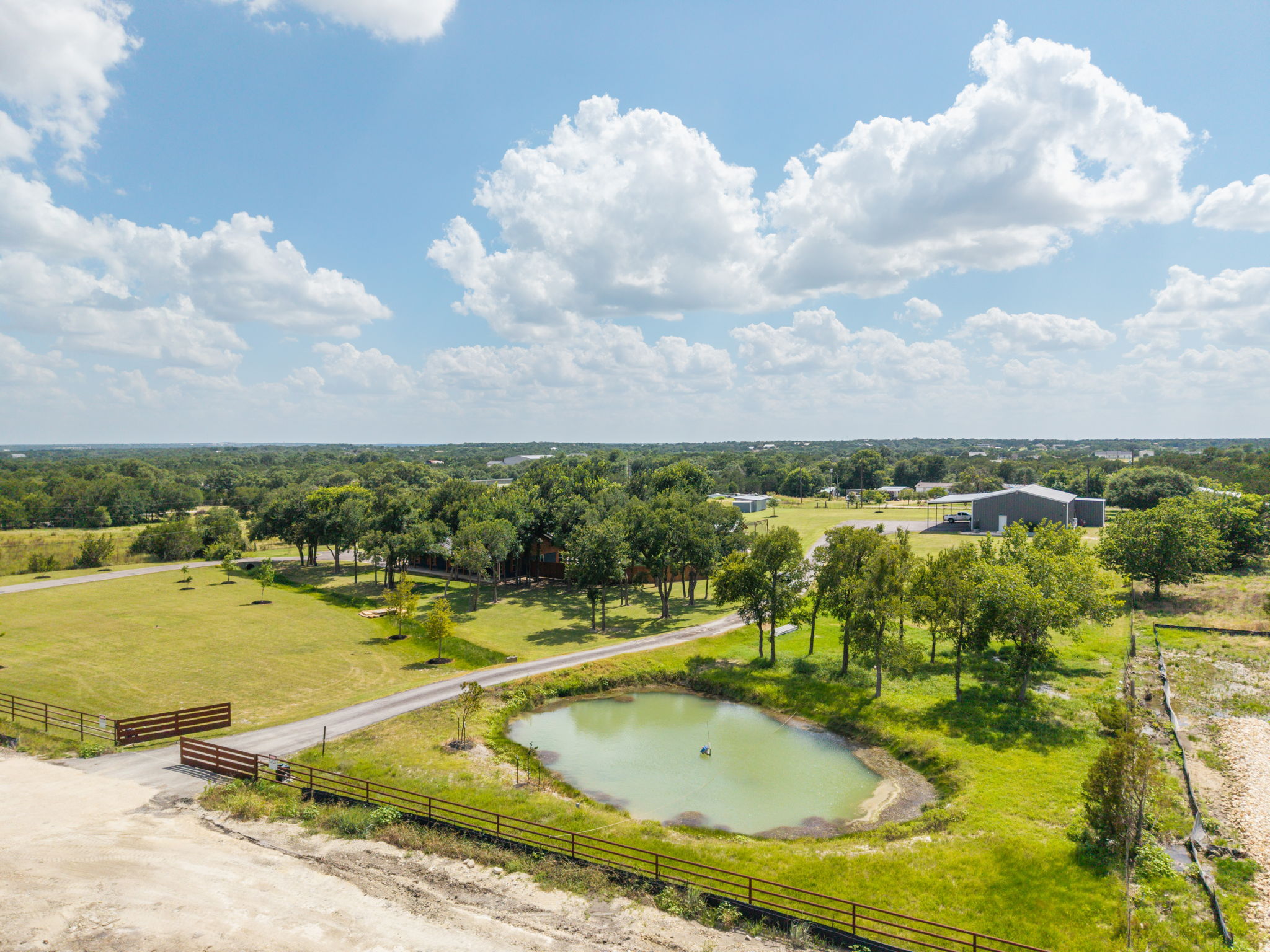 3001 County Road 255 Georgetown, TX 78633 - Photo 27 of 35 A tranquil pond and lush green fields provide a serene rural escape on this expansive property.