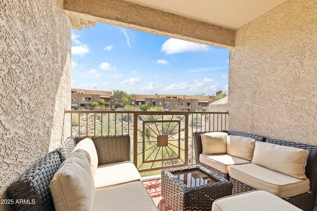 a balcony with furniture and a floor to ceiling window