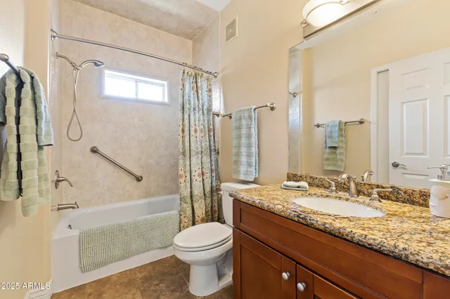 a bathroom with a granite countertop sink a toilet and shower