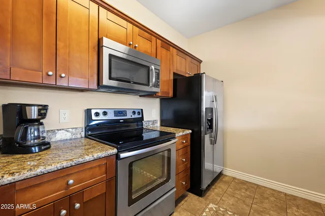 a kitchen with stainless steel appliances granite countertop a stove microwave and sink