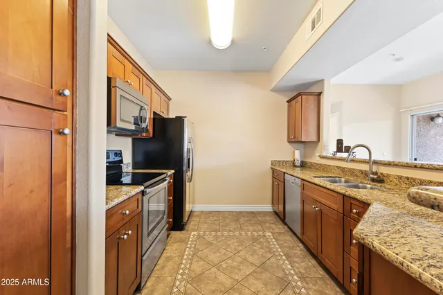 a kitchen with stainless steel appliances granite countertop a sink stove and refrigerator