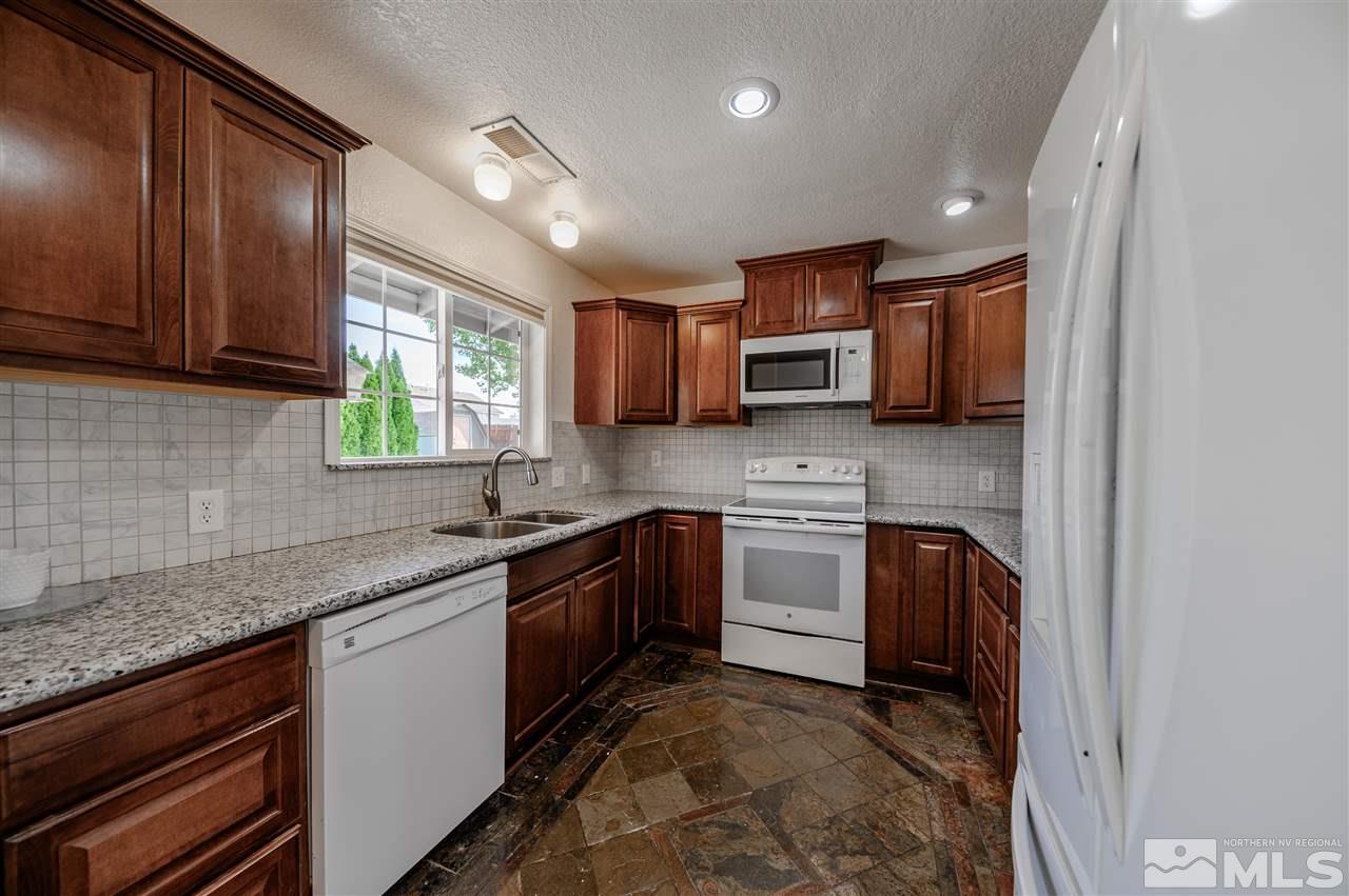301 Hoge Road Reno, NV 89506 - Photo 8 of 23 a kitchen with stainless steel appliances granite countertop sink stove and microwave