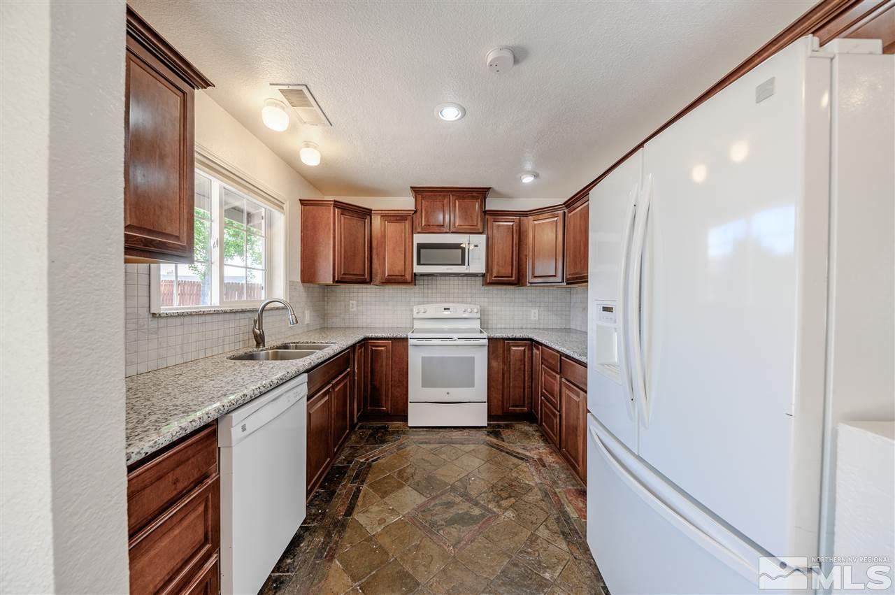 301 Hoge Road Reno, NV 89506 - Photo 10 of 23 a kitchen with granite countertop a sink stove and refrigerator