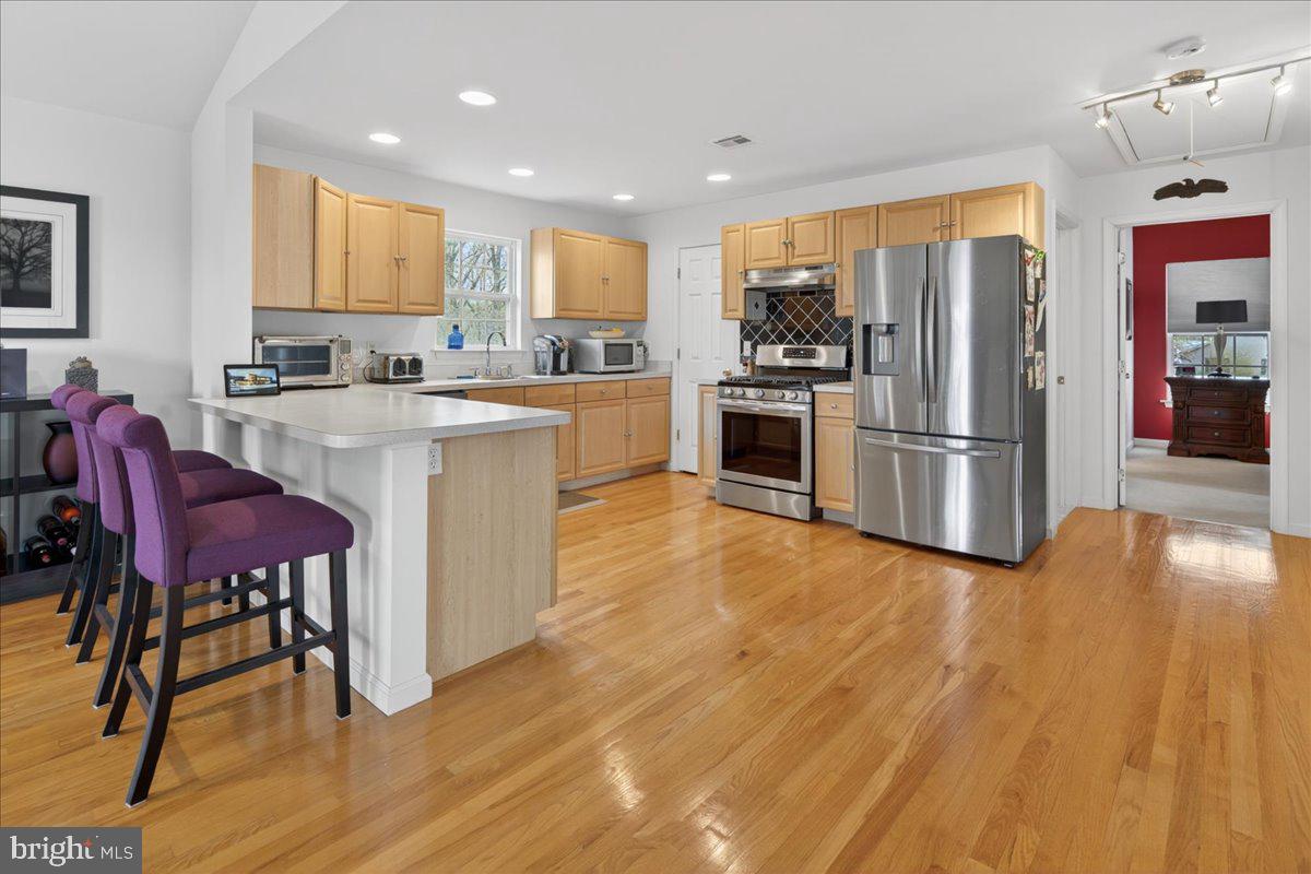 116 Marine Road Waretown, NJ 08758 - Photo 26 of 67 a kitchen with stainless steel appliances granite countertop a refrigerator oven a sink dishwasher and a dining table with wooden floor