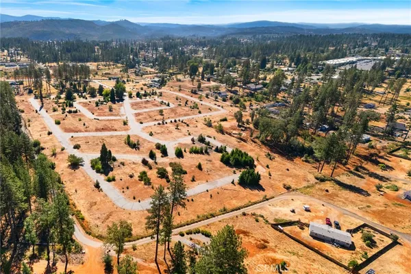 an aerial view of residential house with yard and mountain view in back