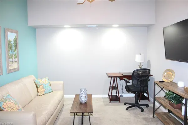 a view of a workspace with furniture and a window