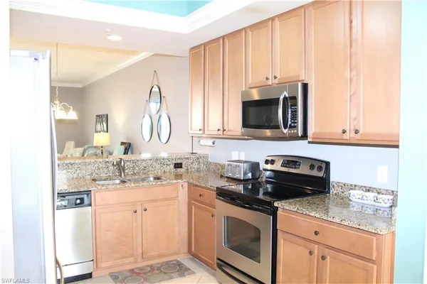 a kitchen with stainless steel appliances granite countertop a stove a sink and a microwave