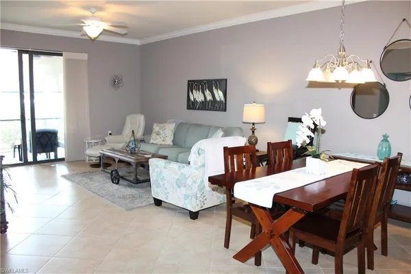 a dining room with furniture a chandelier and window
